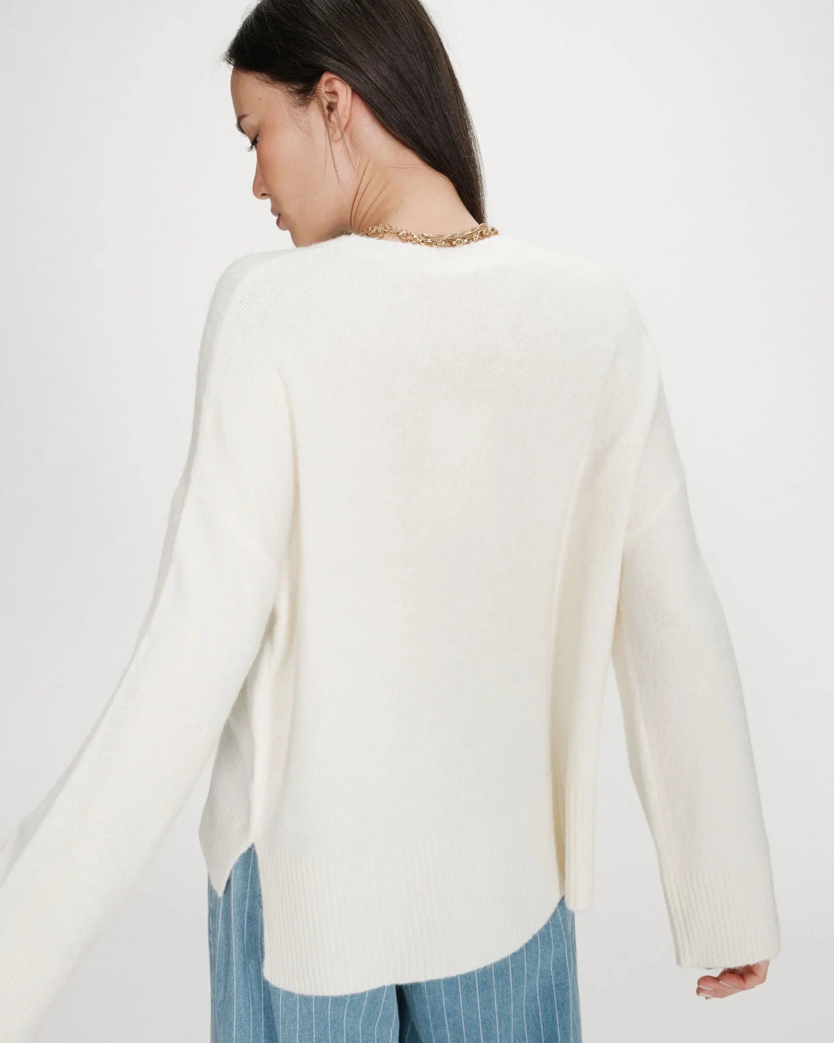 white oversized knit sweater with the text la dolce vita in blue
