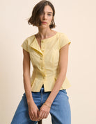 yellow top with buttons down the front and a cap sleeve