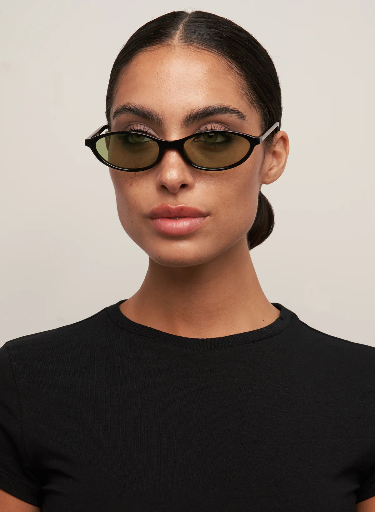 oval sunglasses with a black frame and green lenses
