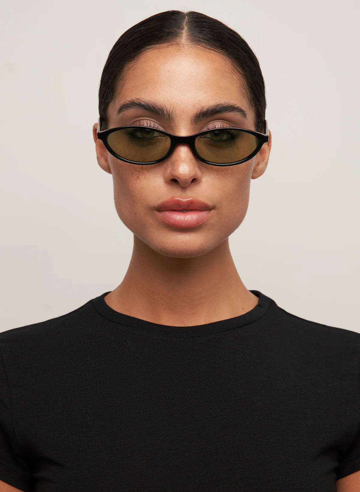 oval sunglasses with a black frame and green lenses