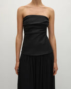 Woman wearing a long black strapless gown 