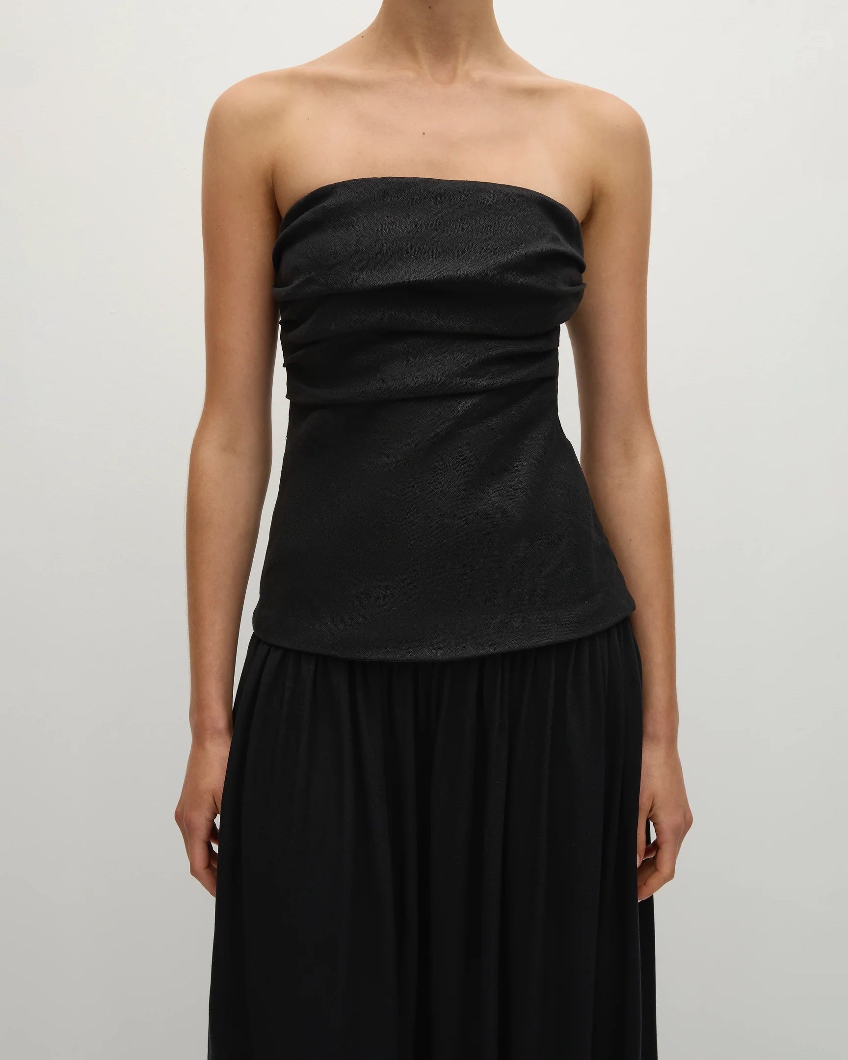 Woman wearing a long black strapless gown 