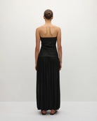 Woman wearing a long black strapless gown 