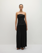 Woman wearing a long black strapless gown 