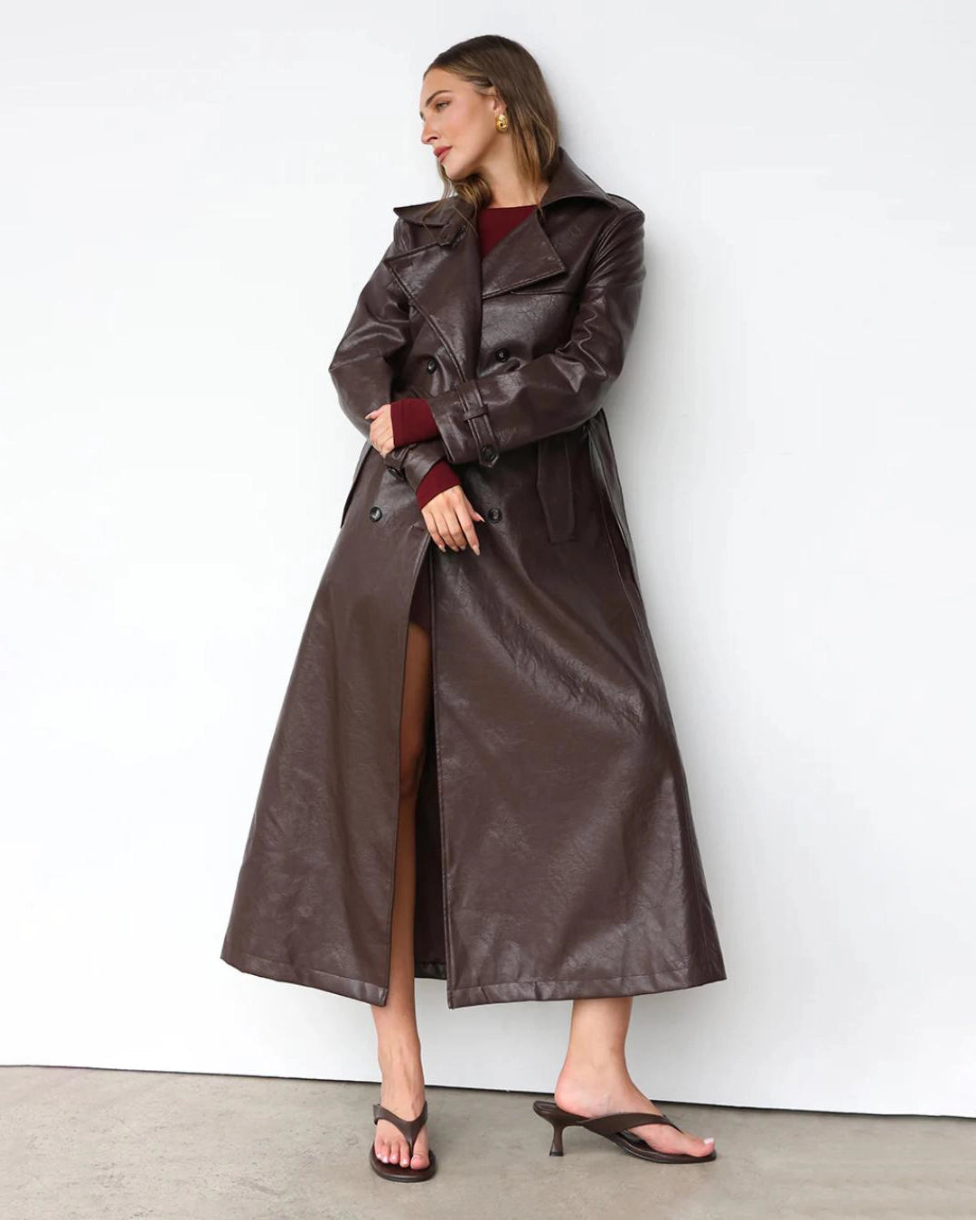 Woman wearing a long brown leather coat 