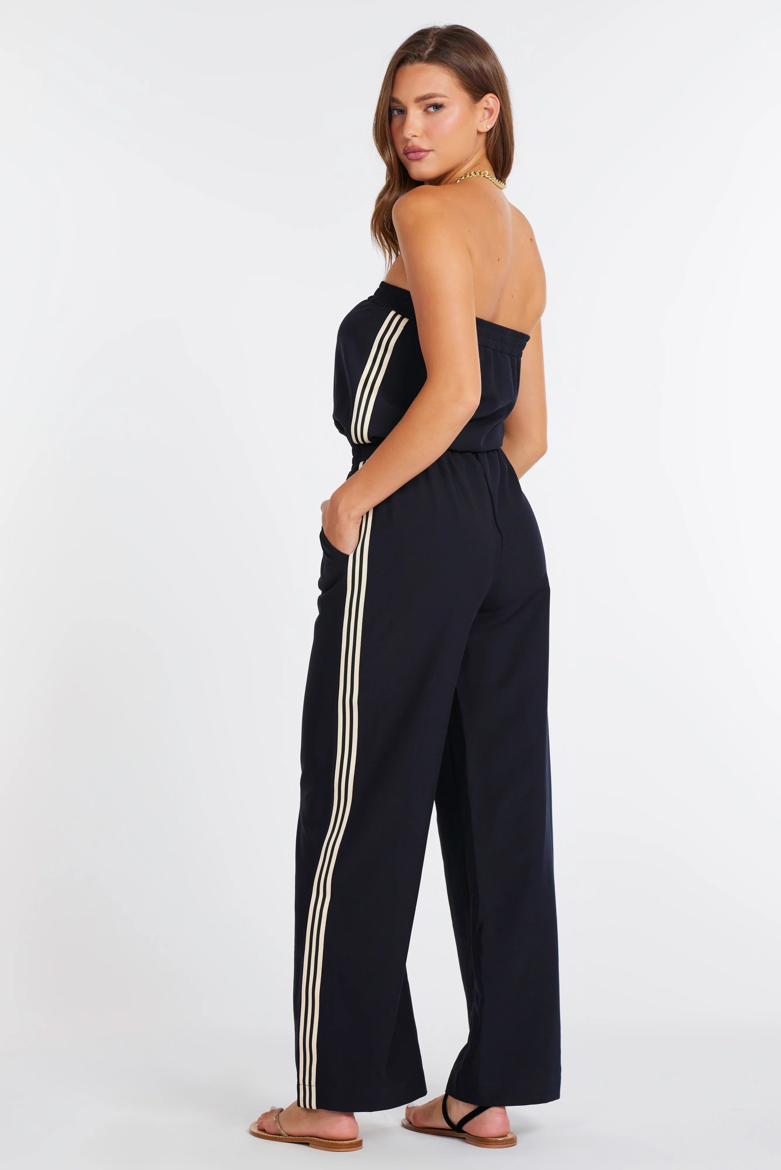 strapless navy jumpsuit with a white stripes down the side
