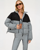 Woman wearing a black and white checkered puffer jacket in black gingham