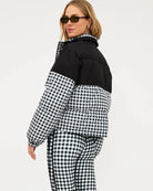 Woman wearing a black and white checkered puffer jacket in black gingham