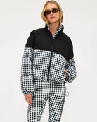 Woman wearing a black and white checkered puffer jacket in black gingham
