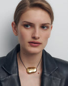 black string necklace with statement gold pendent 