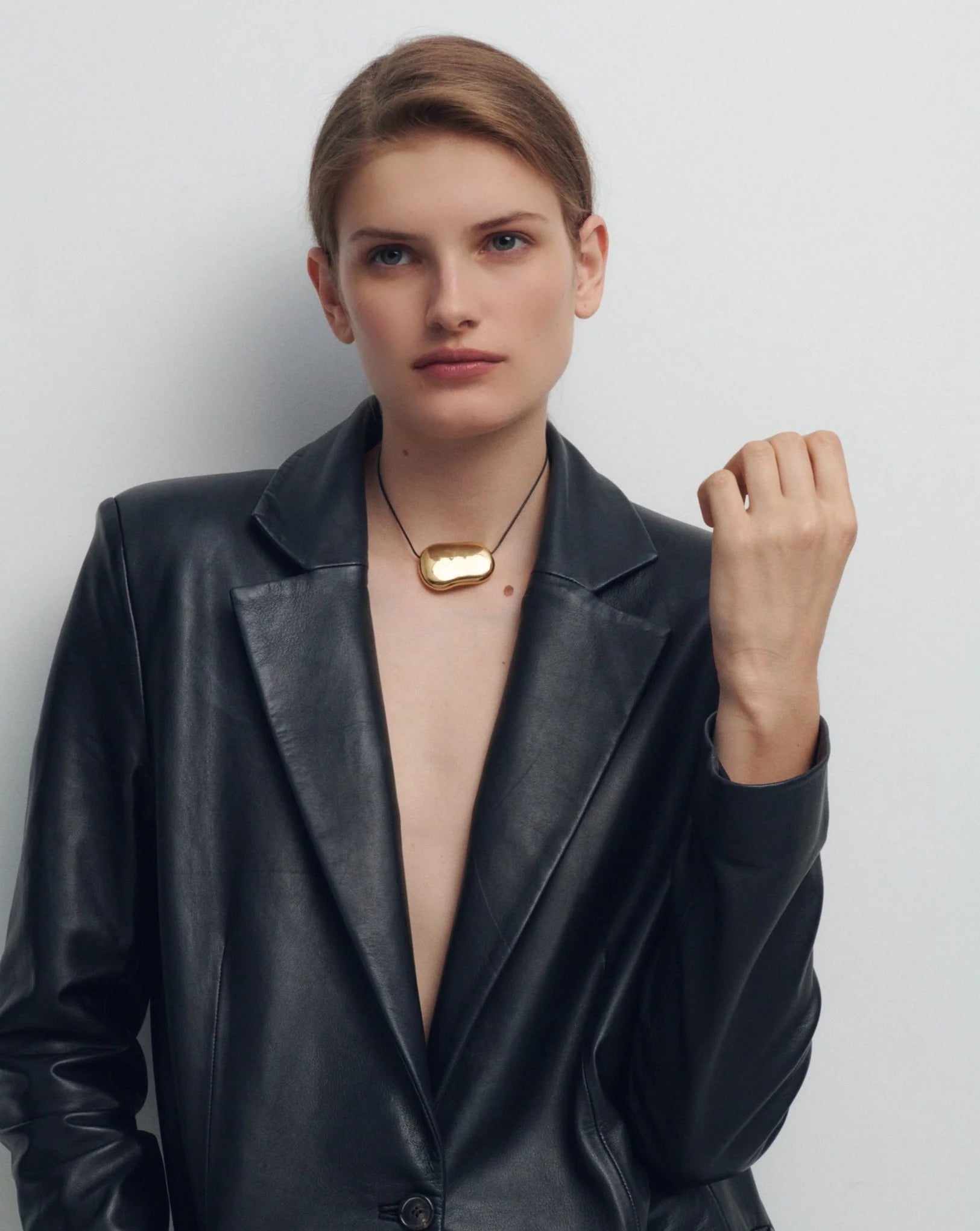black string necklace with statement gold pendent 