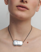 black rope necklace with statement solver pendent