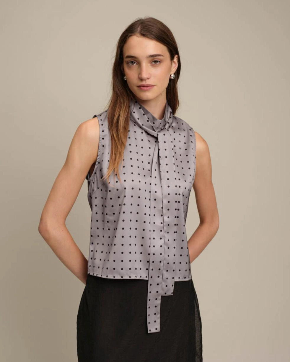 sleeveless blouse in grey with black polka dots and a tie neck