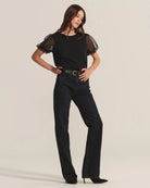 Woman wearing a black top with sheer puff sleeves