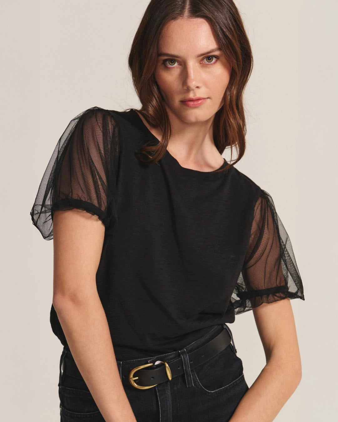 Woman wearing a black top with sheer puff sleeves