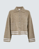 a beige knitted button down jacket with white trim