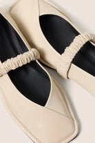 cream leather ballet flat with a square toe and a ruched strap