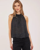 black sleeveless top with white polka dots