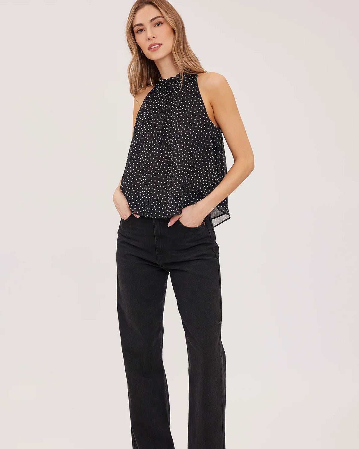 black sleeveless top with white polka dots