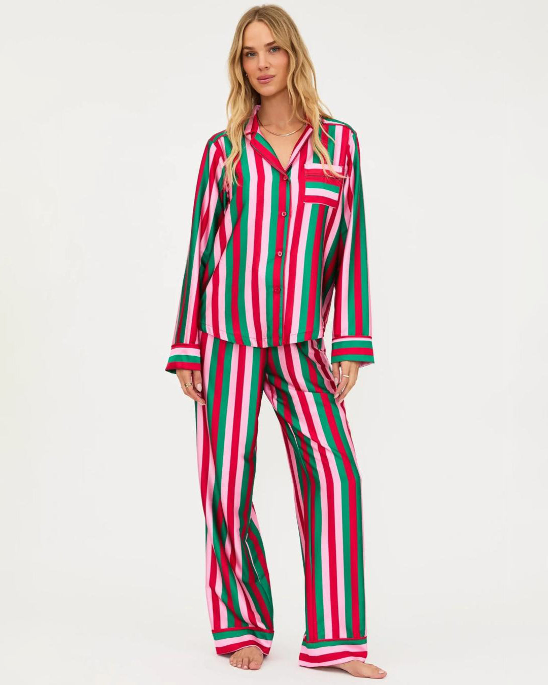 Woman wearing a red, green and pale pink striped pajama set