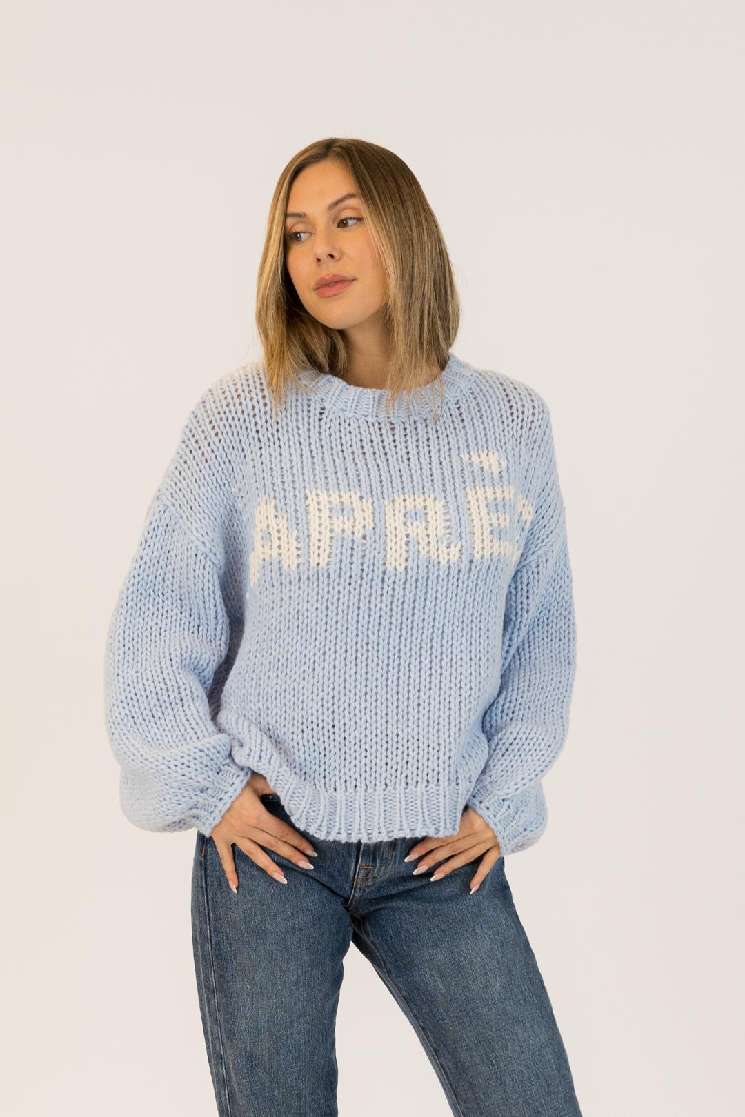 blue knit sweater with apres written on the front