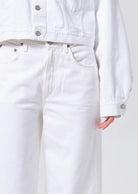 white denim pants with a curve shape and a fray bottom