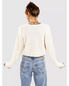 cream knit cardigan that ties in the middle with black trim on the bottom and sleeves