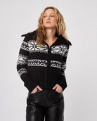 woman wearing a zip up black fairisle cardigan sweater with white pattern