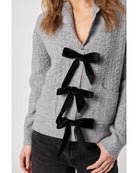 grey cardigan with three black bows down the front