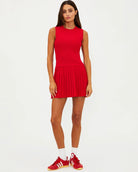 Woman wearing a red sleeveless activewear dress with pleated skirt