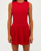 Woman wearing a red sleeveless activewear dress with pleated skirt