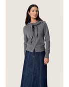 grey cardigan with a scarf attached over the shoulders 