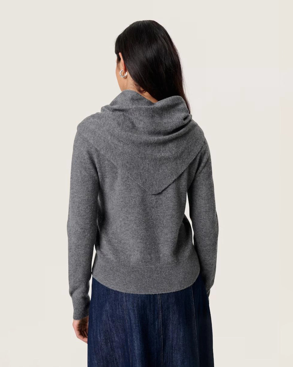 Woman wearing a grey button down cardigan sweater with a tie front scarf design 