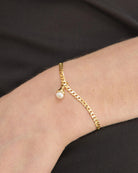 gold bracelet with a pearl charm