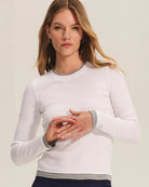 Woman wearing a white long-sleeve top and navy pants