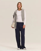 Woman wearing a white long-sleeve top and navy pants