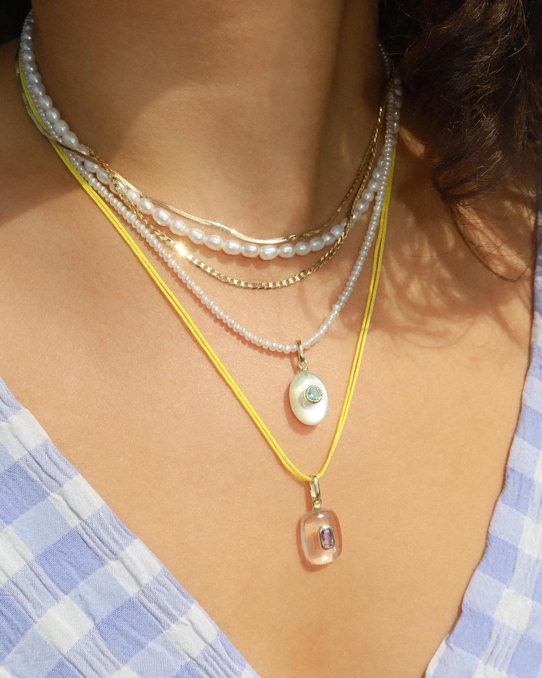 pearl charm with a birthstone in the middle