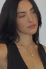 A video of a woman wearing  gold chain necklace with a big oval crystal pendant by brand Lili Claspe