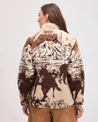 Woman wearing a patterned jacket with horse design in brown and beige