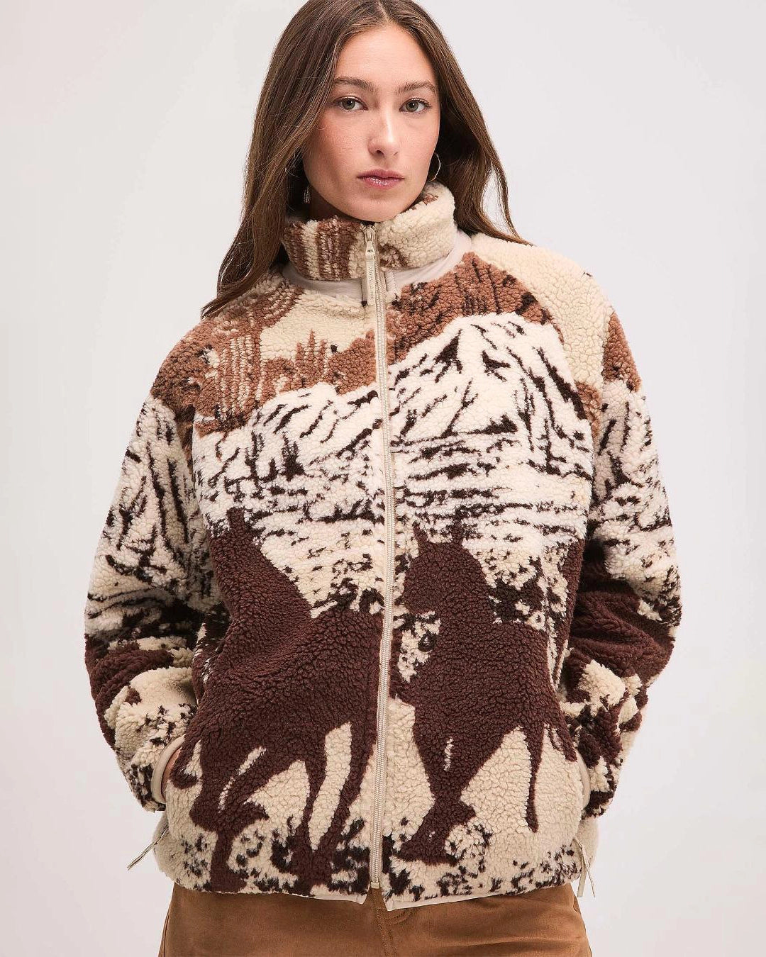 Woman wearing a patterned jacket with horse design in brown and beige
