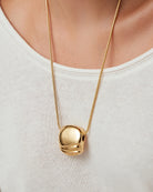 necklace with a statement gold pendant on a long thick gold chain