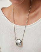 necklace with a statement solver pendant on a long thick silver chain