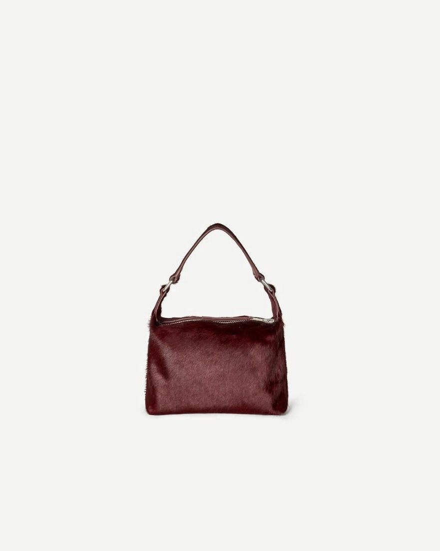 small purse with cow hair and leather in a burgundy