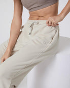 close up of beige sweatpants with pockets and a draw string