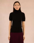 Woman wearing a black turtleneck tee sweater and maroon skirt