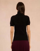Woman wearing a black turtleneck tee sweater and maroon skirt