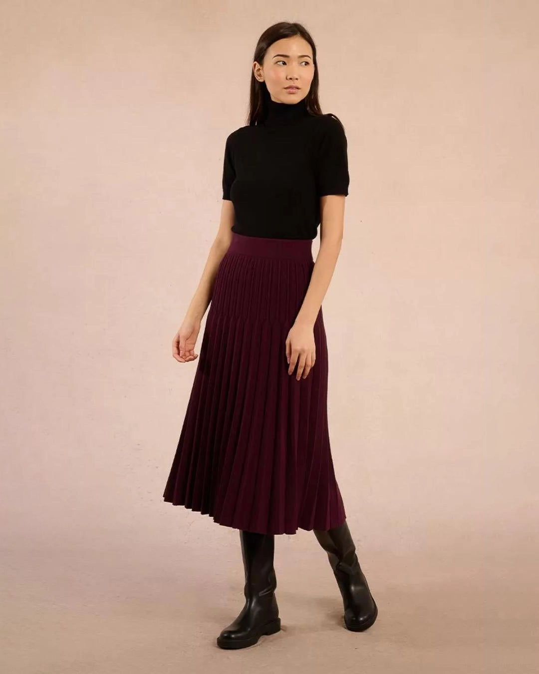 Woman wearing a black turtleneck tee sweater and maroon skirt