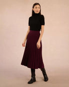 Woman wearing a black turtleneck tee sweater and maroon skirt