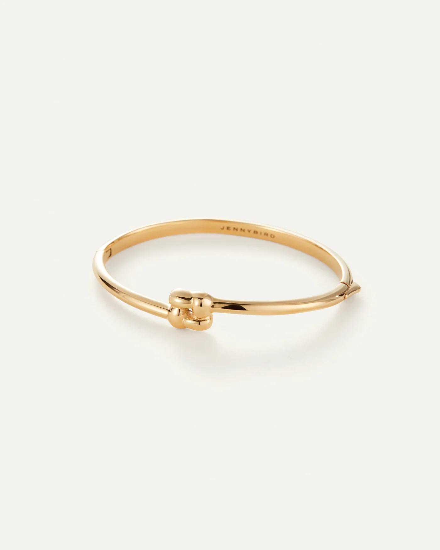 gold slim bangle with a woven design pendant 