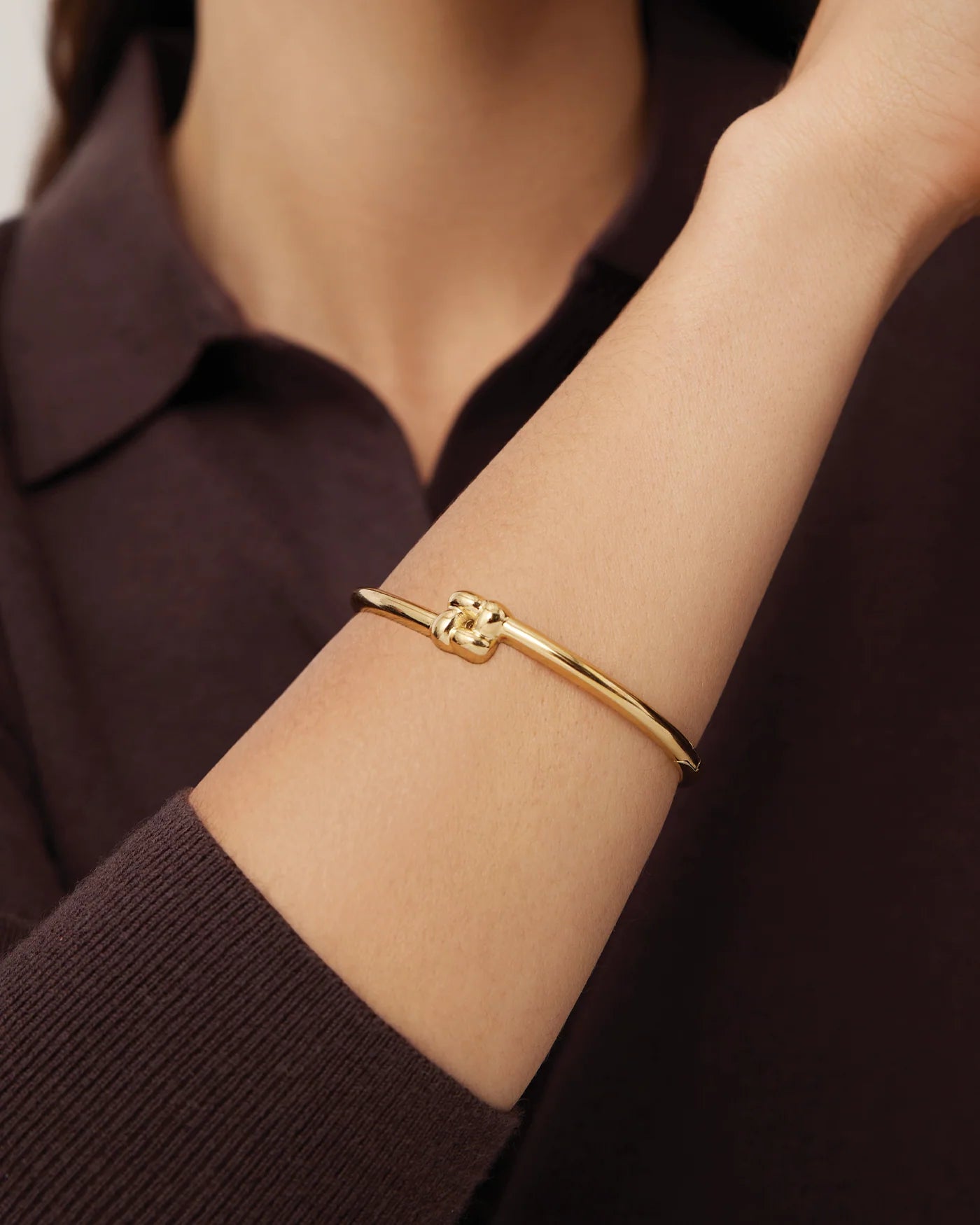 gold slim bangle with a woven design pendant 